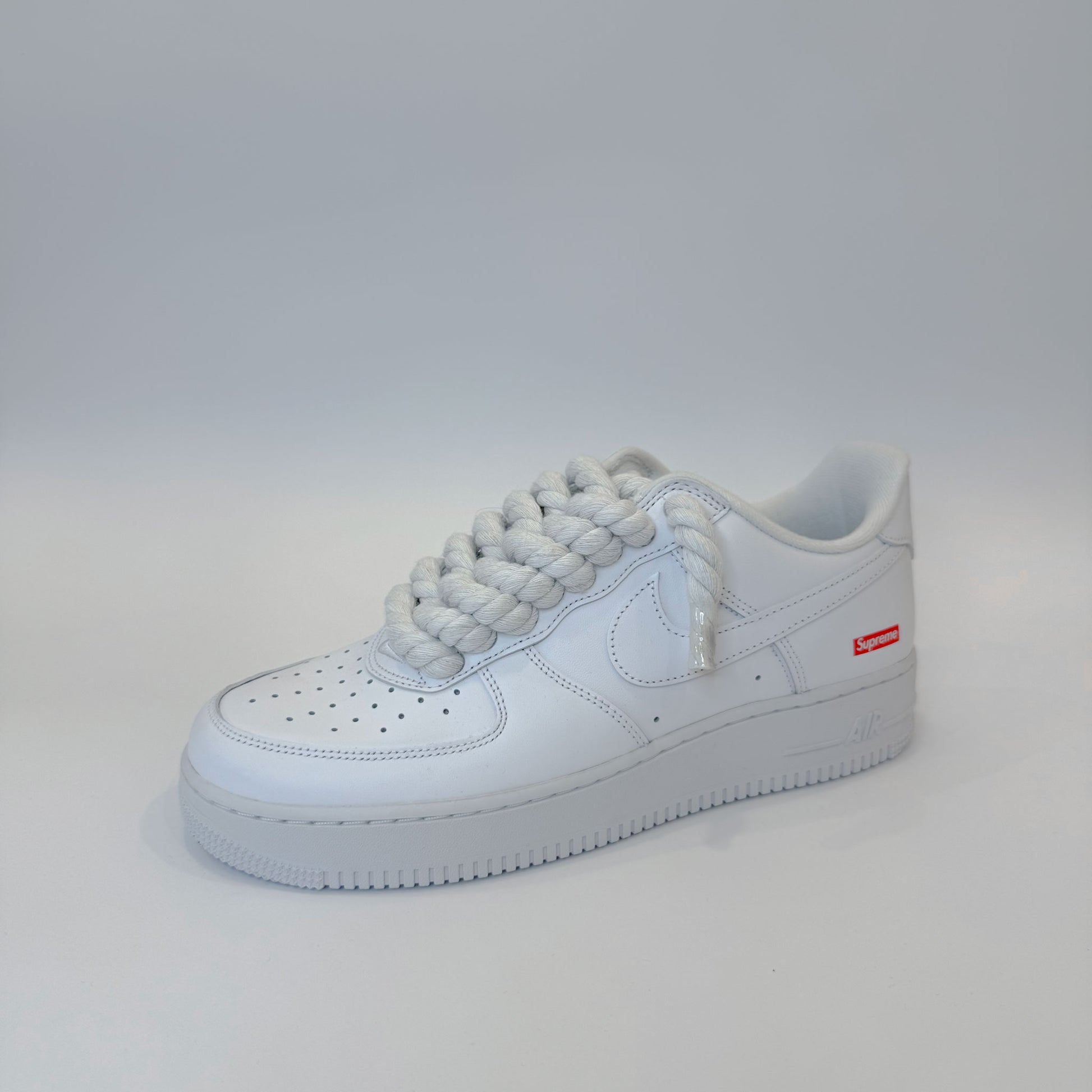 Pohľad na Nike Air Force 1 Low Supreme White – detail bielej kože a bielych custom šnúrok.