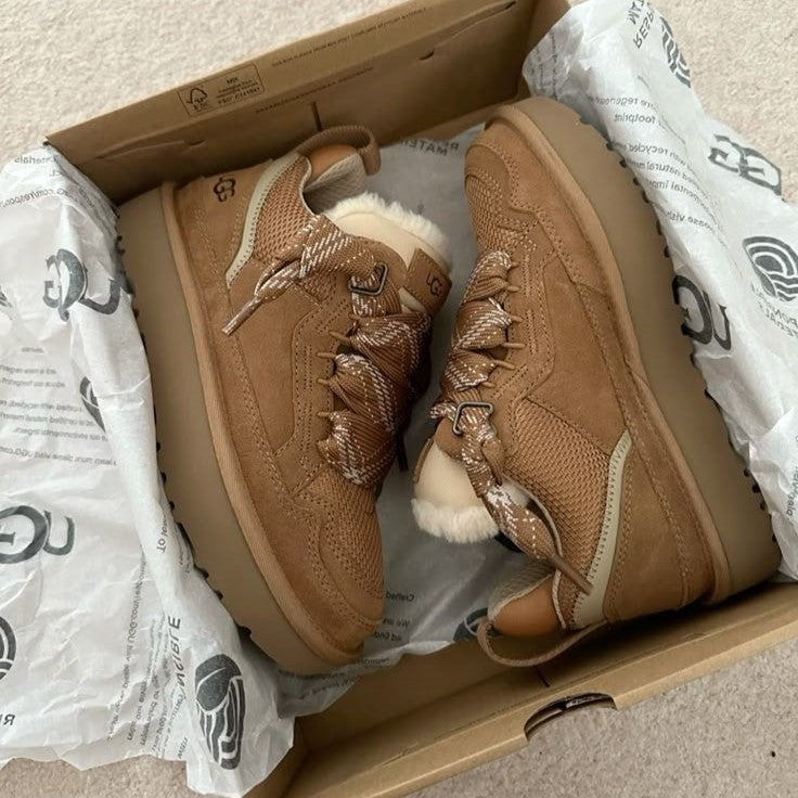 Detail tenisky UGG Lowmel Chestnut v ruke – prémiový semiš, mäkké materiály a kvalitné spracovanie.